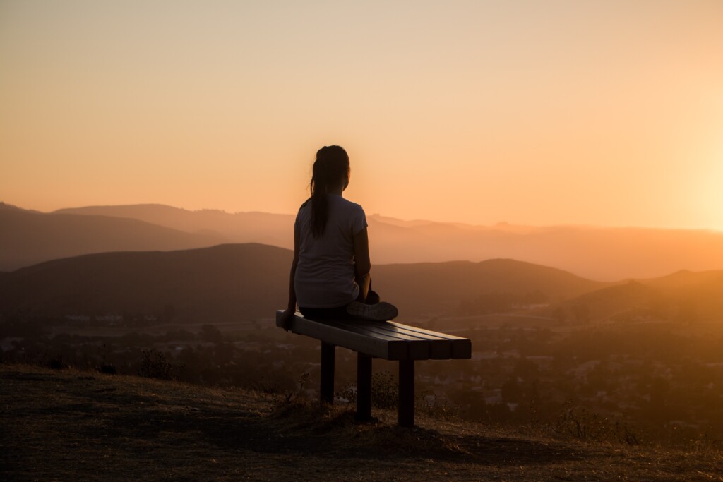 woman meditating looking into the San Diego sunset