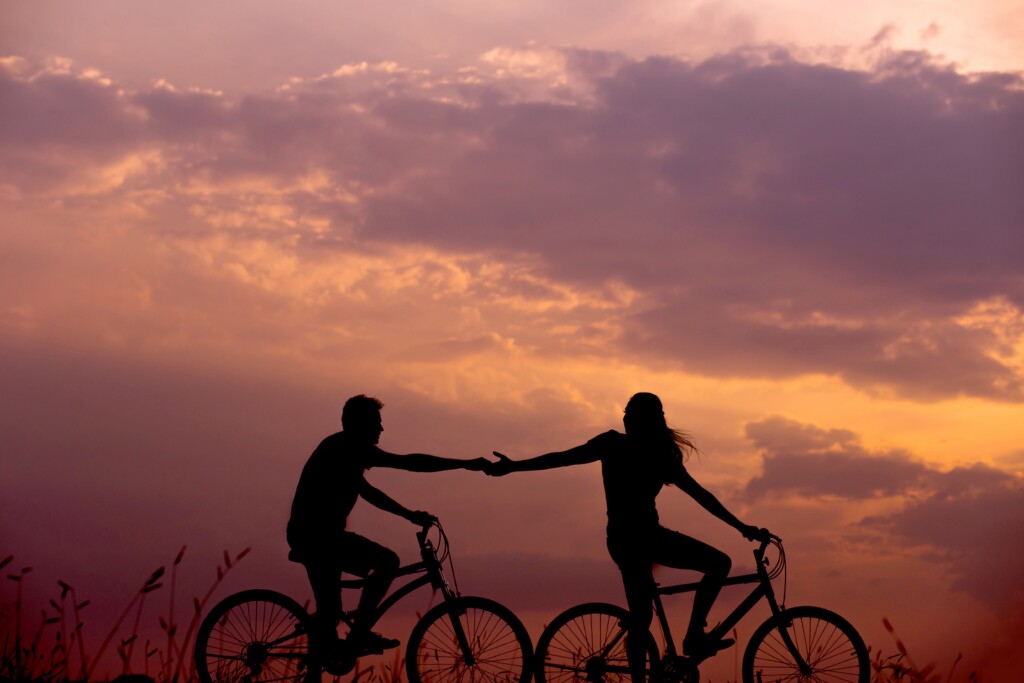 healthy active couple riding bikes in the sunset