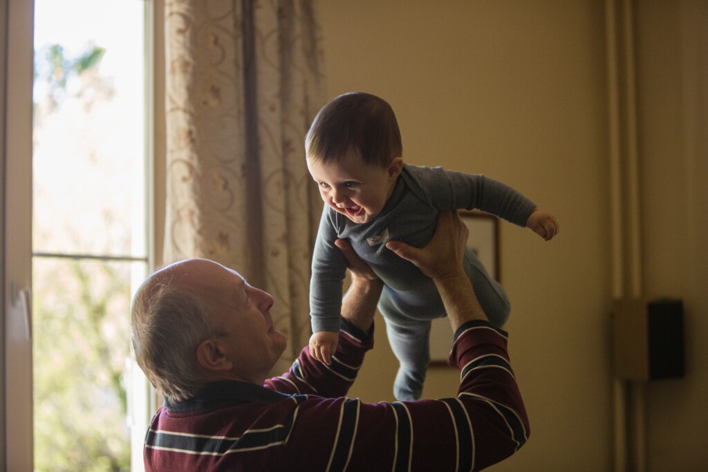 Elder man aging gracefully playing with child